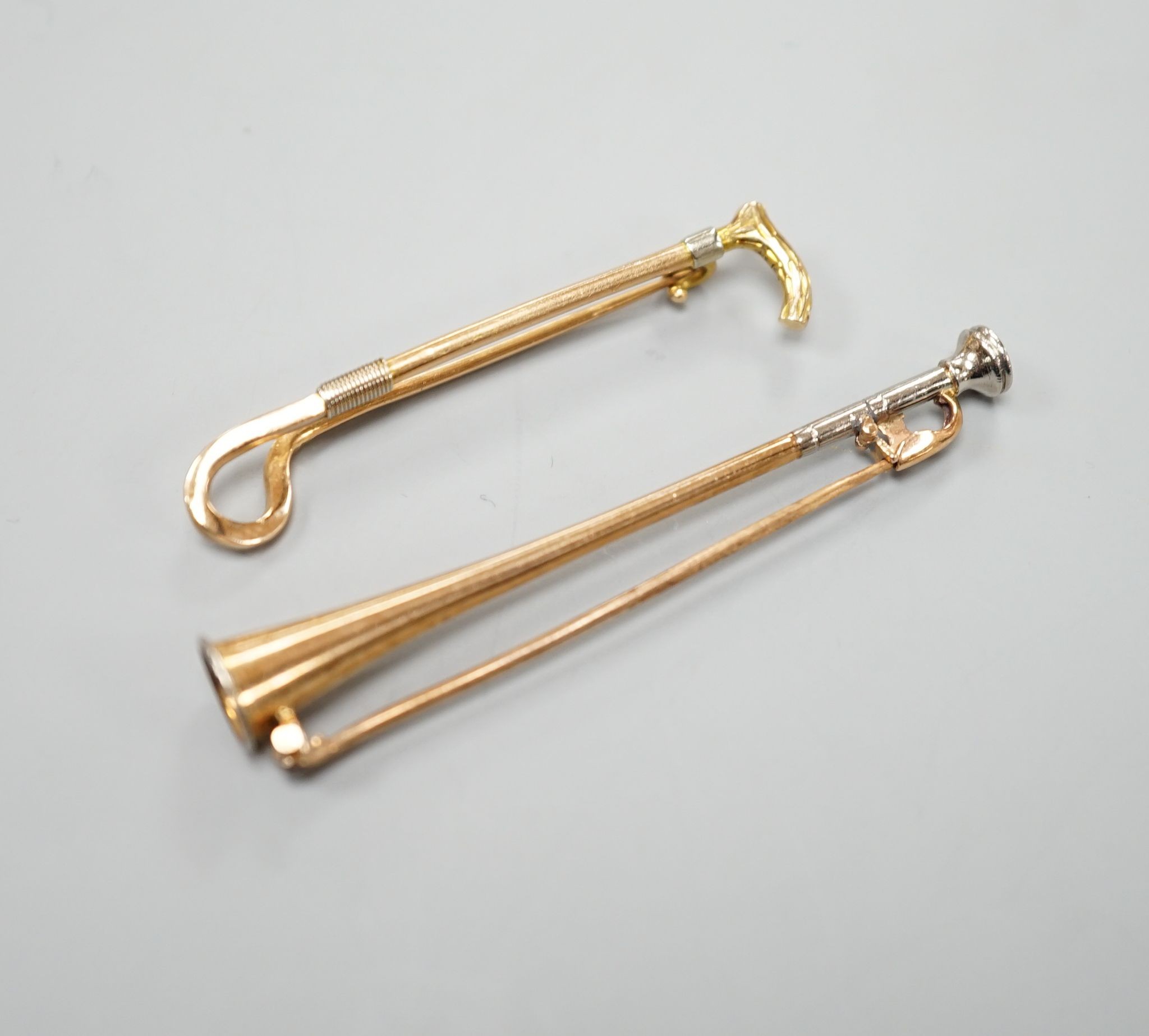 An Edwardian 15ct riding crop bar brooch, 44mm, 3.1 grams and a similar yellow and white metal hunting horn bar brooch, 56mm, gross 3.8 grams.